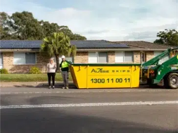 Customer Standing in front of their house with a hired skip bin