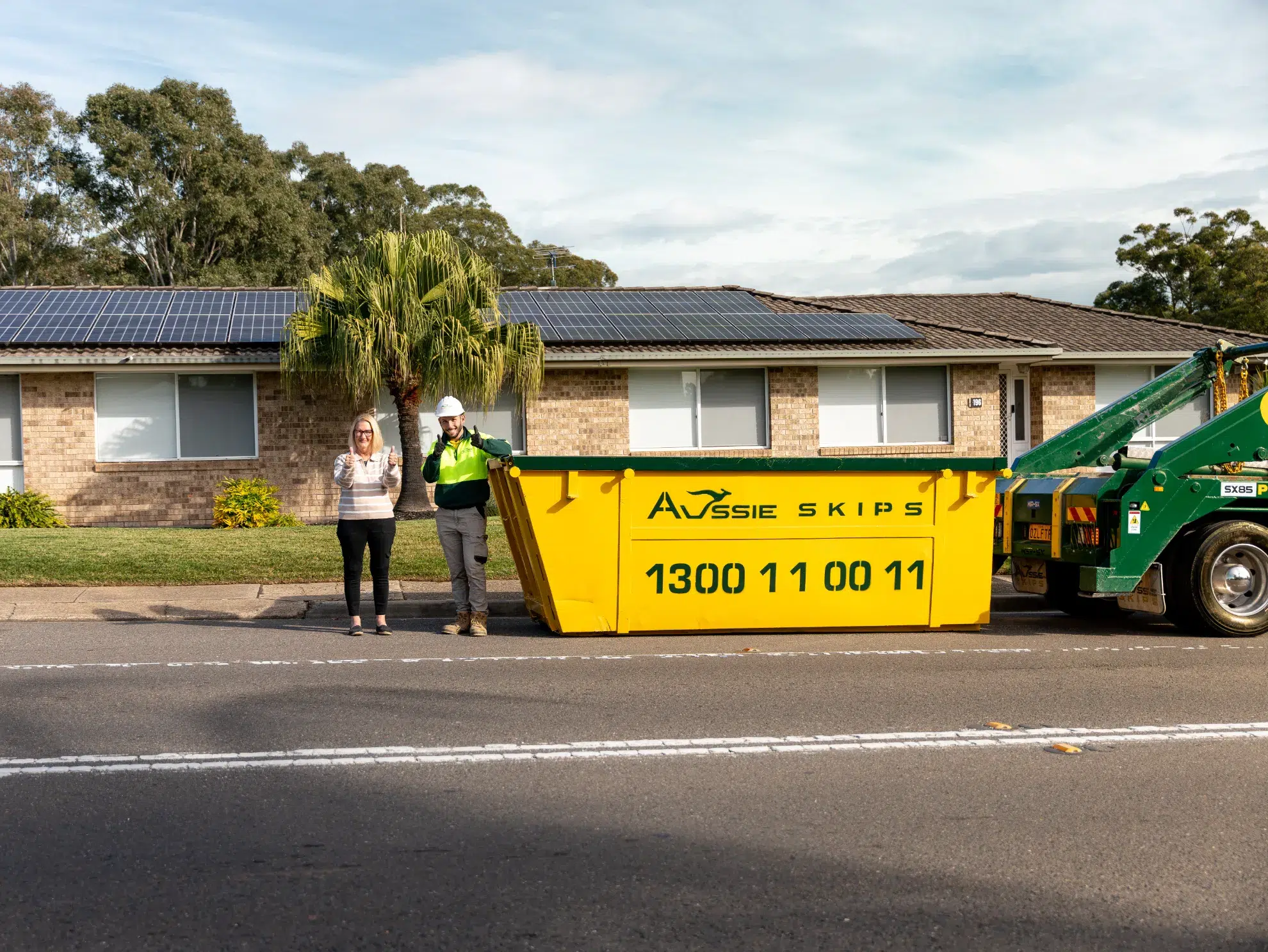 Customer Standing in front of their house with a hired skip bin