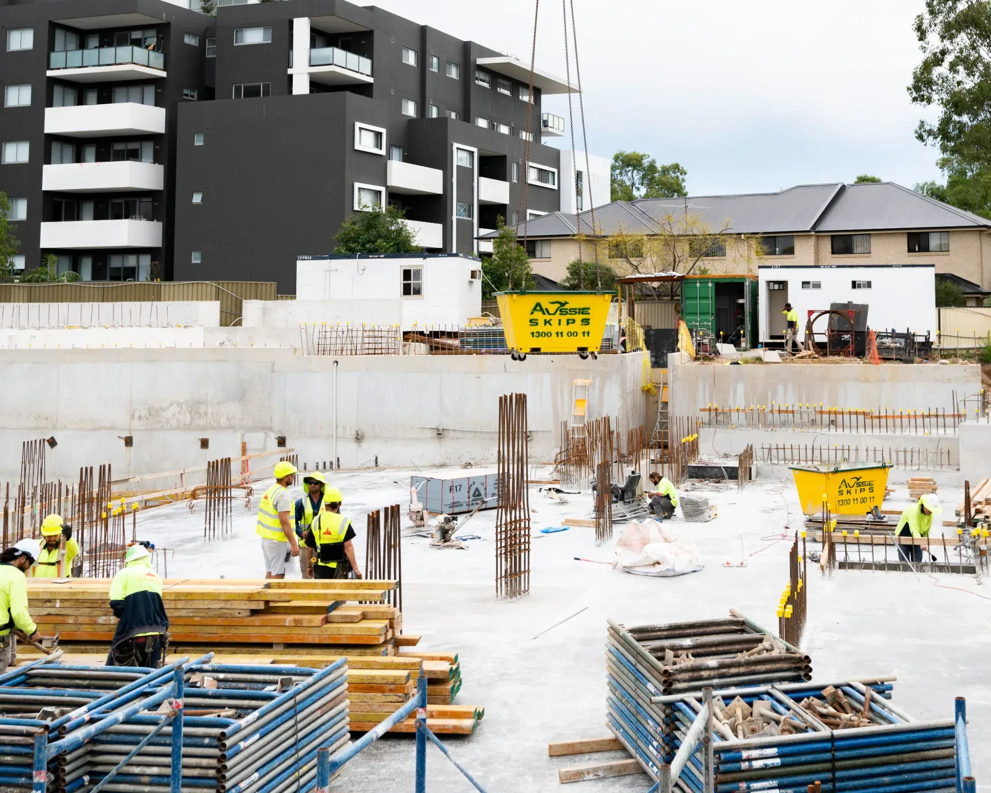 Hired Aussie Skip bins being delivered to construction site with crane